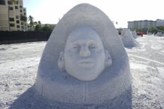 a face on a pedestol sand sculpture