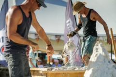 water-sand-shovels and a team working on their sand sculpture