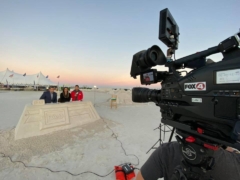 fox news reporting from the sand sculpting championship behind a sand sculpted desk